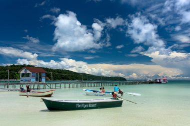 Motor boat with tourist on the board very close to the pier. Cambodian man takes tourists to the resorts.   Koh Rong Samloem island, Saracen Bay. Cambodia, Asia. 08 September 2017 clipart