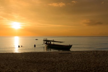 Sunset Beach gemi ve turist Denizde yüzme ile güzel günbatımında. Koh Rong Samloem, Kamboçya. 