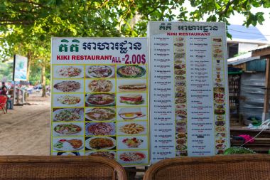 Bilgi yönetim kurulu menüsüyle restoran Kiki önünde. MPay uygun Bay balıkçı köyü. Kamboçya, Asya, 25 Ekim 2017