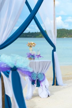 Tablo şampanya bardakları ve deniz kabuğu ile dekore edilmiştir. Tropik sahilde düğün hazırlıkları.