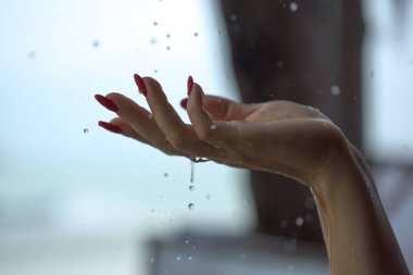 Kadının eline düşen yağmur damlaları 