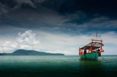Yeşil Longtail tekne Koh Ron Samloem, Kamboçya plajına yakın Saracen koyda demirlemiş. Arka planda gökyüzü üzerinde güzel bulutlar. 