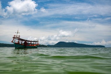 Yeşil Longtail tekne Koh Ron Samloem, Kamboçya plajına yakın Saracen koyda demirlemiş. Arka planda gökyüzü üzerinde güzel bulutlar. 
