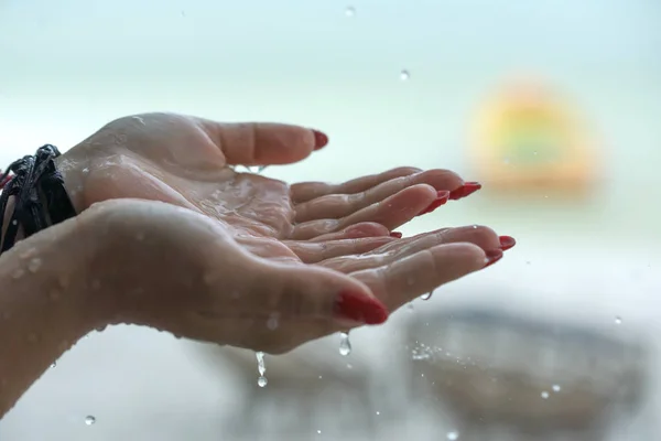 Rain drops falling on womans hand