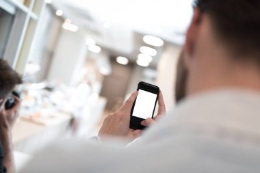 Elinde cep telefonu olan bir iş adamı resim çekmeye çalışıyor. İzole cep telefonu ekranı.