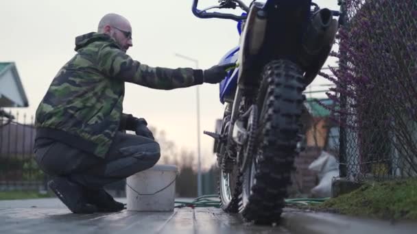 Νεαρός Πλένει Motocross Χέρι Χρησιμοποιώντας Ένα Πινέλο Και Μάνικα Προετοιμασία — Αρχείο Βίντεο