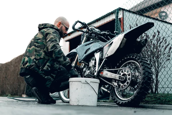 27 Mart 2020 Wroclaw - Motocross Yamaha WR 250r genç adam tarafından yıkandı. Motosiklet bir garajın önünde duruyor. Motosiklet gezintiye hazırlanıyor.. 