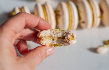 Elinde şam fıstıklı, ısırılmış bir makarna var.