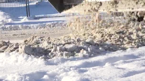 Traktor ze specjalnym wyposażeniem zwolnić śniegu na ulicy w pobliżu domów w zimie. 4k — Wideo stockowe