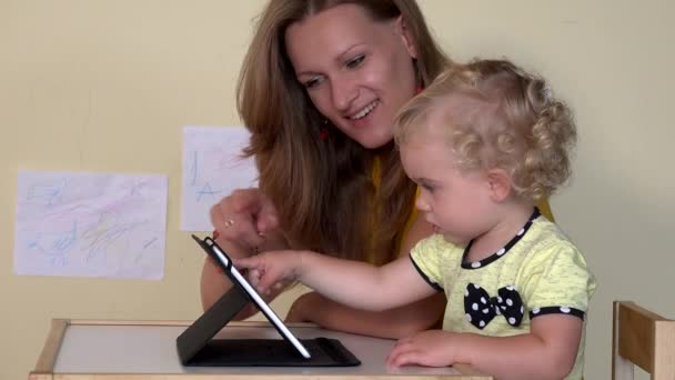 Niñera enseñando a niña usando tableta — Vídeo de stock