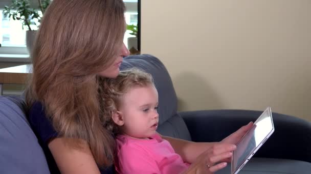 Madre mujer enseñando niña pequeño usando tableta — Vídeo de stock
