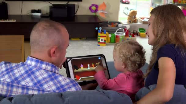 Happy family father mother and baby girl playing game with tablet computer. — Stock Video