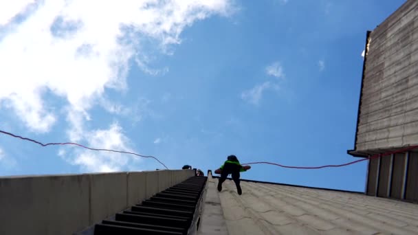 Fearless people descend down with safety cord on skyscraper high building wall. — Stock Video