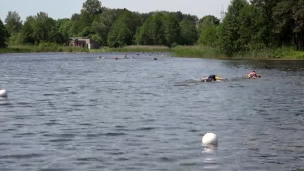 Extreme competition participants floating on finfoam over lake water. — Stock Video