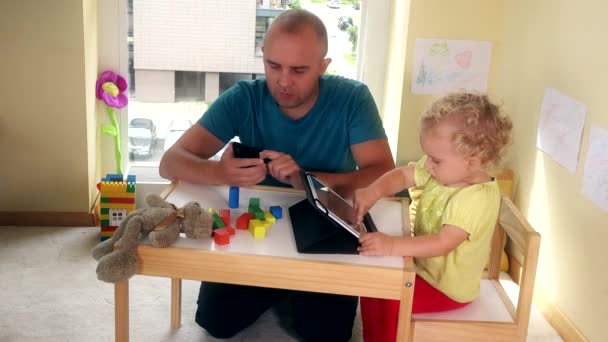 Father with smart phone and toddler girl playing with tablet computer — Stock Video