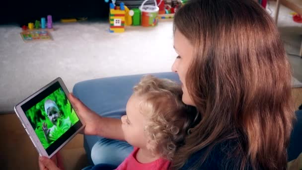 Chůva k pohledání žena s malým dítě dívka sledovat rodinný film na obrazovce počítače tablet — Stock video