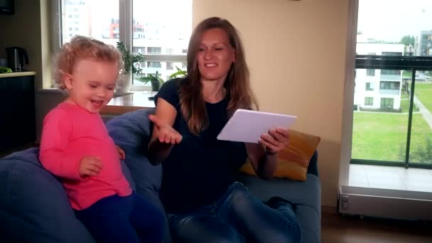 Ευτυχισμένη μητέρα με την κόρη του το κορίτσι να διασκεδάσουν ακούγοντας μουσική στον υπολογιστή tablet — Αρχείο Βίντεο