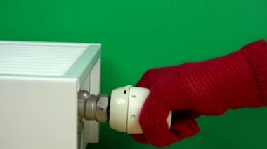 Radyatör termostat saplı ev sıcaklığı ayarlama eldiven ile el.