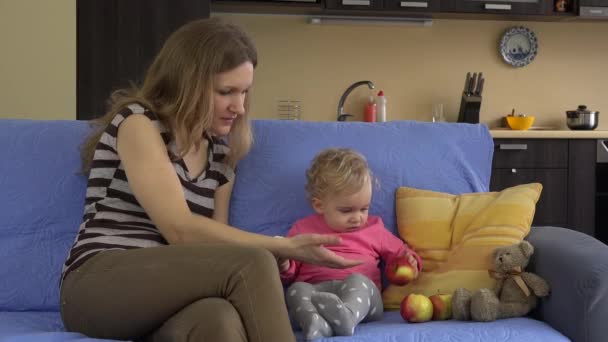 Madre y su pequeño hijo comiendo frutas rojas y saludables de manzana . — Vídeos de Stock