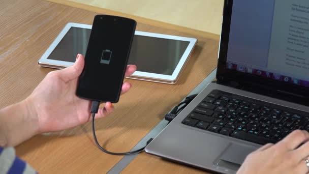 Business woman using laptop touch pad and hold charging smart phone. closeup — Stock Video