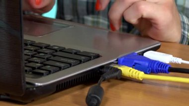 Laptop klavye ve touchpad üzerinde yazmadan eller. Kabloların bağlı.