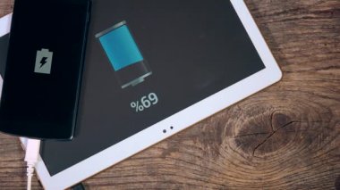 El ahşap arka plan üzerinde usb kablosu için tablet bilgisayar ve telefon bağlanmak