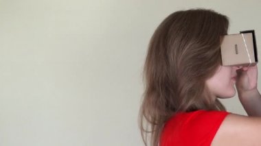 Geriye doğru vr sanal gerçeklik karton gözlük ile yürüyen meraklı kadın