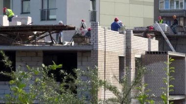 Profesyonel tuğla örme ustaları çalışanlar beyaz tuğla yeni evin duvarında elinizdeki.