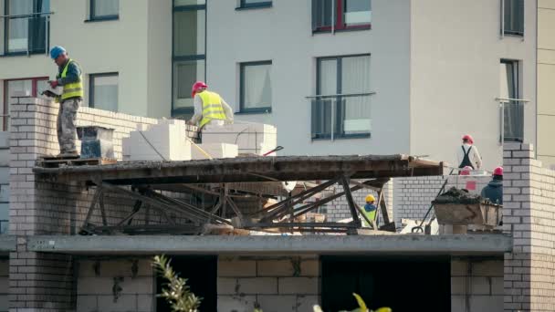 Construction mason workers bricklayer installing white brick with trowel putty — Stock Video