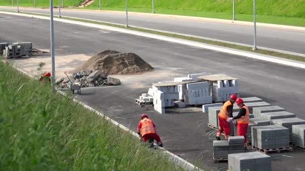 Workers paving new sidewalk pavement near highway road — Αρχείο Βίντεο