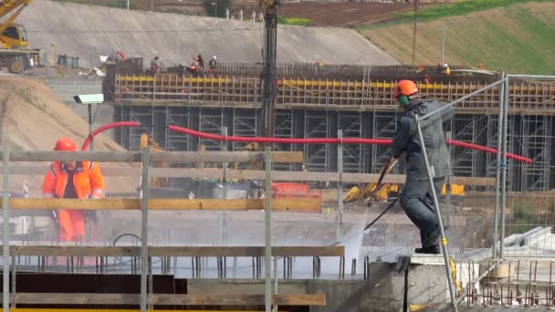 Munkás ember öntözni beton nagynyomású víz eszközzel a közúti viadukt — Stock videók