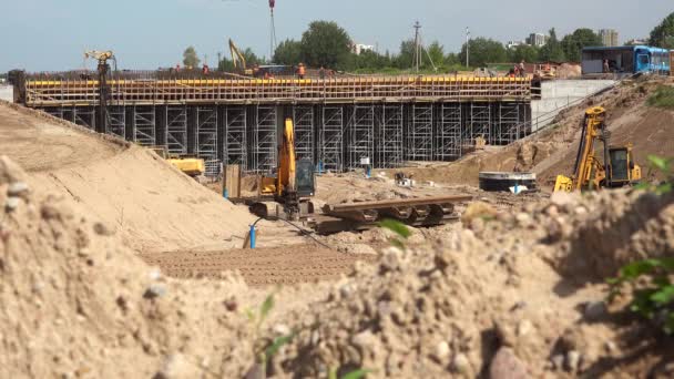 Sandhaufen und professionelle Arbeiter-Brigade beim Bau des Autobahnviadukts — Stockvideo