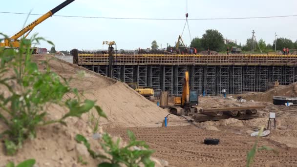 Erdhaufen und professionelle Arbeiter-Brigade beim Bau des Autobahnviadukts — Stockvideo
