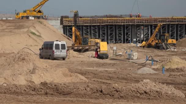 Worker man pouring diesel fuel into generator and highway constructing work — Stockvideo