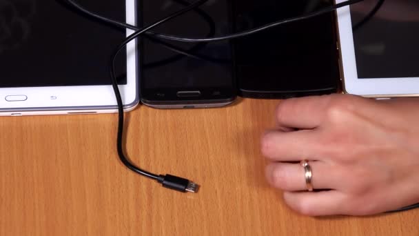 Female hand connect micro usb cable to tablets and phones plugs — Stock video