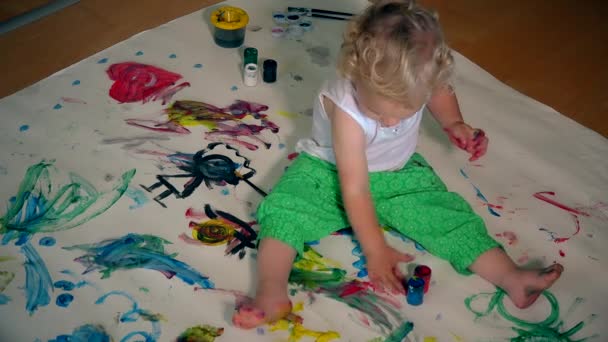Смешной малыш с грязными руками, рисующий на полу и одежде — стоковое видео