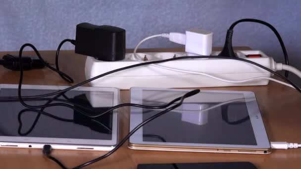 Les mains féminines branchant les dispositifs chargeurs aux prises d'extension sur la table 