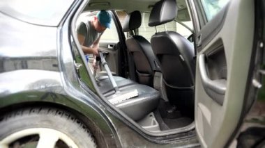 istemci araba elektrikli süpürge ile çalışan adam.