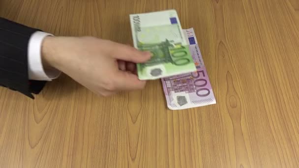 Человек считает наличные евро банкнотами на столе. 4K — стоковое видео