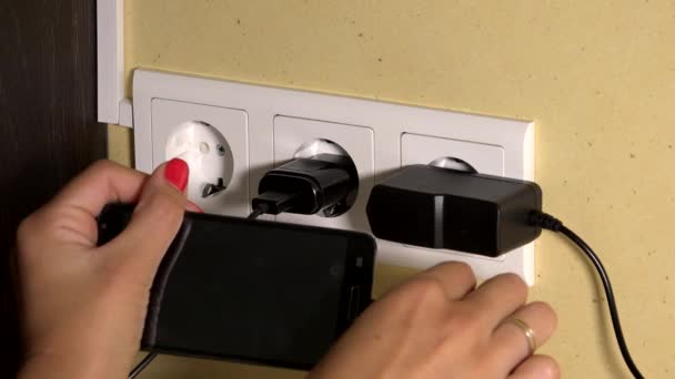 Woman hand attach smart phone to wall charger and hold — Stock Video