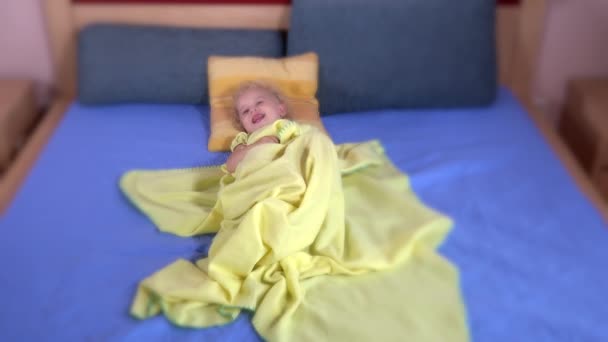 Glad söt barn gömmer sig under pläd sjal på säng — Stockvideo