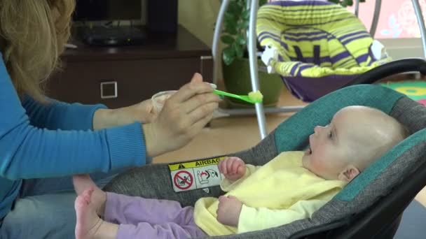 Anne el ile püre kaşık içinde aç bebek bebek besleme. 4k — Stok video