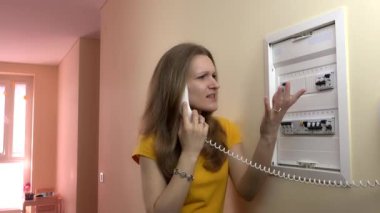 Güzel kadın elektrikçi tel telefon devre kesici kutusunun yakınında bulunan danışın