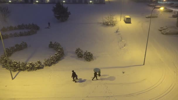 Människor går i levande hus distrikt på tung snö falla blizzard. 4k — Stockvideo