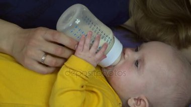 Sevgi dolu bir anne yeni doğan kız süt tozu şişe ile beslenir. 4k