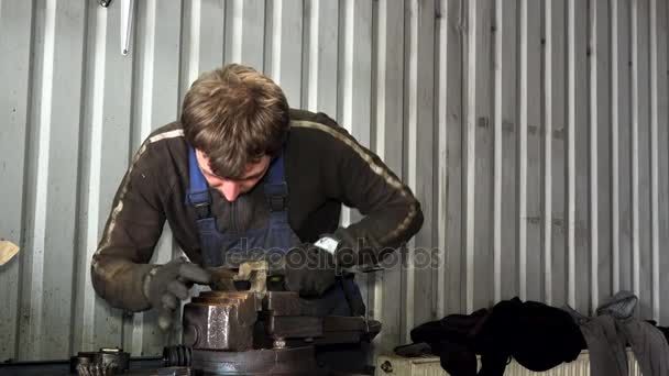 mužské mechanik grind rezavý kov nástrojem rašple v garáži.