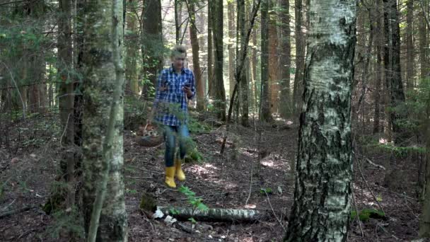 Smiling lost mushroom picker woman holding cellphone with gps in forest — Stock Video