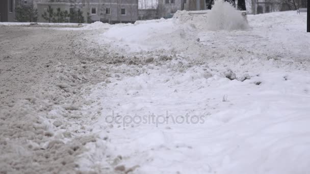 Man cleans snow from street sidewalk via snow removal machine. Closeup. 4K — Stock Video