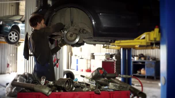 Man met spanner gereedschap losschroeven remschijven van tweedehands auto 's. — Stockvideo