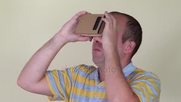 Мужчина разворачивается, держа очки виртуальной реальности. Крупный план — стоковое видео
